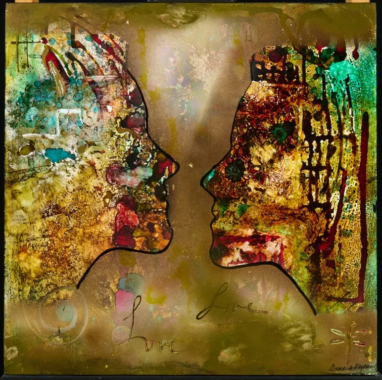 A mixed-media painting featuring two human face profiles facing each other. The profiles are outlined in thin black lines against a mottled, golden background with a metallic sheen. The inside of each profile is filled with a complex collage of textures and colors, including abstract shapes, patterns, and what appear to be floral or leaf motifs. The left profile has more green and turquoise, while the right has deep reds and browns. The word "love" is written twice in script near the bottom center, and a signature is in the bottom right corner.
