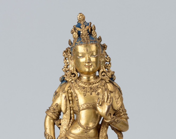 upper half of a golden statue of a bodhisattva