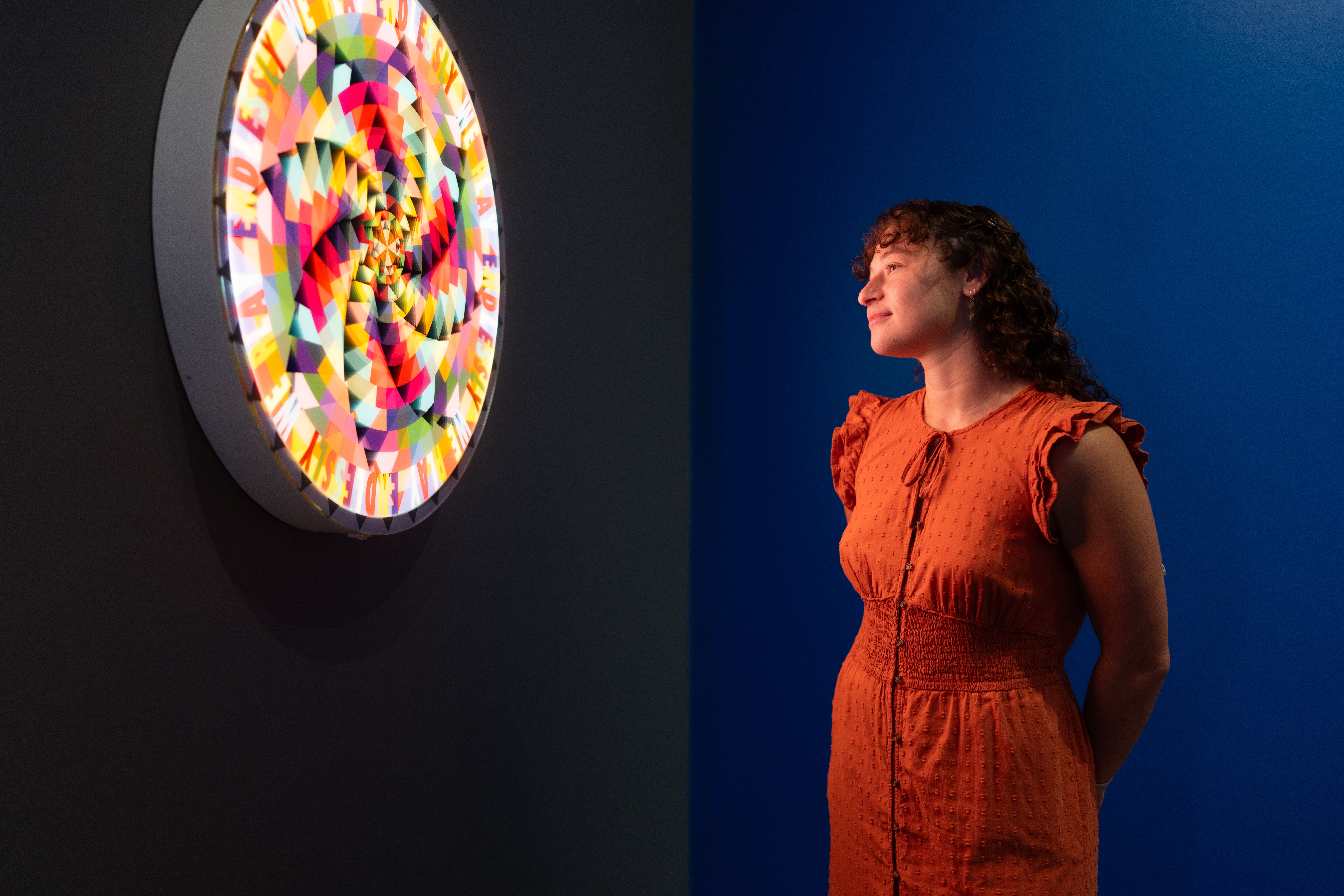 A woman gazes at a Jeffrey Gibson work of art. 